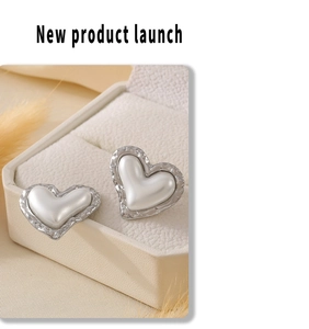 Detailed view of heart-shaped silver earrings with pearl inlay in a jewelry box