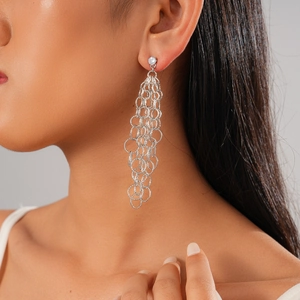 Gros plan de boucles d'oreilles à pompon argenté avec zircon sur un mannequin