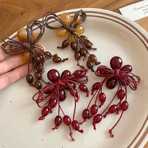 Vintage resin beaded bow earrings with long tassel in deep red and amber finish