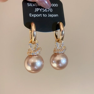 Vue détaillée d'une boucle d'oreille en perle champagne avec serti pavé de zircons
