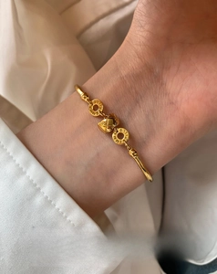 Detailed view of the 18K gold plated quilted pattern cuff bracelet on a female wrist