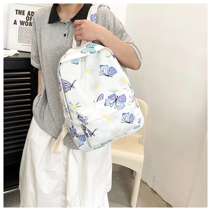Detail of white canvas backpack featuring purple butterfly and yellow daisy floral prints