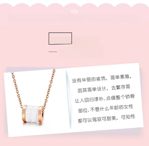 Detail van een roségouden cilinderhanger met wit keramisch inlegwerk aan een ketting