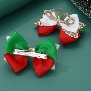 Detail of Christmas bow hair clips with gold crown and sequin fabric on green background