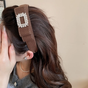 Close-up of brown velvet headband featuring sparkling square rhinestones worn by a model