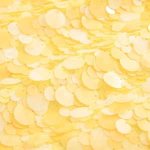 Macro view of densely arranged yellow sequins and texture on a stylish skirt