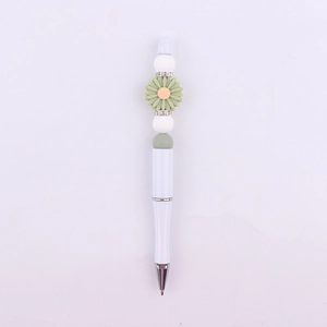Detail view of DIY beaded pen with white plastic body and green daisy silicone charm