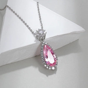 Elegant water-drop pink zircon pendant necklace with crystal inlay on a minimalist stand