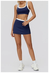 Detail of navy blue high-stretch sports bra and tennis skirt with white contrast trim