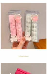 Detail of pink and green hair root clips for volume in a 2-piece set with long grips