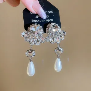 Elegant floral drop earrings with sparkling crystals and a large teardrop pearl pendant