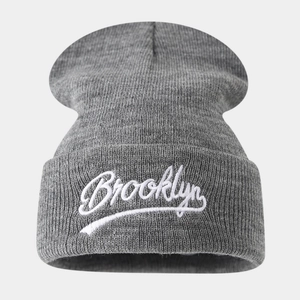 Detail of Brooklyn embroidery on grey knitted beanie with ribbed texture and folded cuff