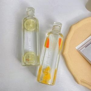 Detail view of transparent glass water bottles featuring time markers and fresh fruit tea