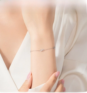 Close-up of S925 sterling silver infinity bracelet with sparkling stones on a model wrist