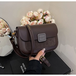 Detail of dark brown vintage shoulder bag with gold hardware and stitching texture