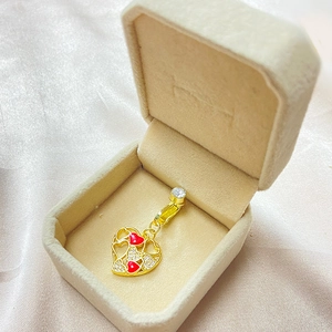 Détail d'un anneau de nombril coeur doré avec émail rouge et cristaux dans son coffret
