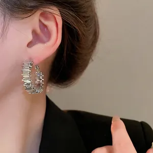 Minimalistische silberne unregelmäßige Creolen mit strukturierter Oberfläche am Modell