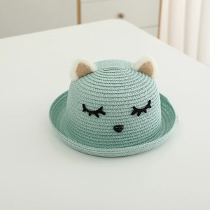 Dettaglio cappello di paglia verde menta con orecchie di gatto e ciglia ricamate bimbi