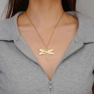 Golden dragonfly pendant necklace in 18K stainless steel worn by a female model