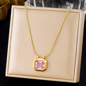 Close-up of gold snake chain necklace featuring a rectangular pink crystal pendant