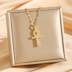 Collier croix Ankh dorée serti de micro-zirconiums avec une chaîne raffinée