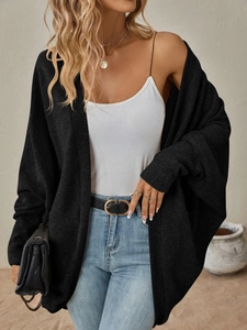 Dettaglio di un cardigan nero in maglia con maniche a pipistrello e trama fine