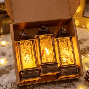 Three bronze Christmas LED lanterns with snowman and reindeer patterns in a gift box
