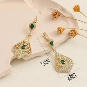 Detail showing vintage gold teardrop earrings with green gems, 6.5cm length measurement
