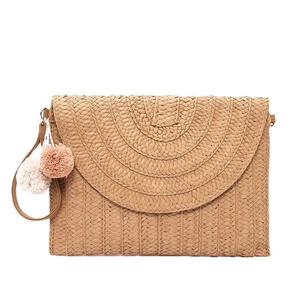 Handwoven straw clutch bag with colorful decorative pom poms for beach vacation