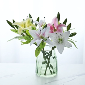 Detail of 3-head faux lilies in white and pink colors within a green glass vase