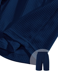 Detailed macro view of dark blue waffle knit fabric texture on men's casual shorts