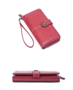 Detailed view of red long wallet for women with white stitching and textured leather