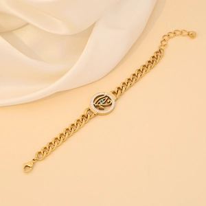 Gold evil eye pendant necklace with crystals on beige silk background for women