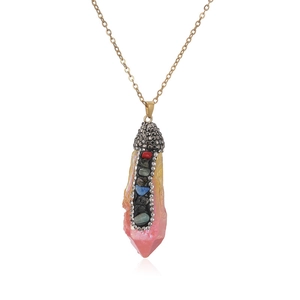 Macro detail of natural crystal pendant with golden chain and colorful rhinestone accents