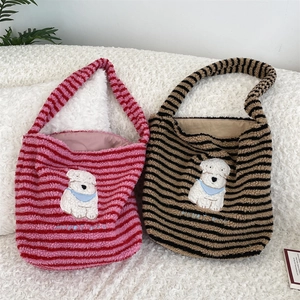 Detailed view of plush tote bag featuring cute cartoon dog embroidery and stripe pattern