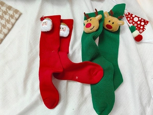 Details von festlichen Weihnachtsstrümpfen mit 3D-Nikolaus- und Rentier-Plüschfiguren