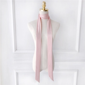 Detailed close-up of a long pink satin scarf tied elegantly on a mannequin neck