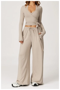 Detail of female long-sleeve cross wrap crop top and drawstring high-waist wide-leg pants