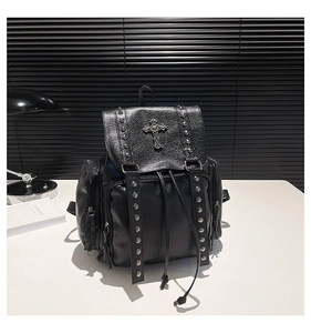 Detail of lychee pattern leather backpack with silver gothic cross and rivet accents
