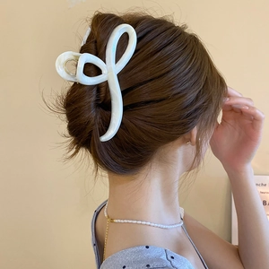Elegant pearl white hair claw clip shown in a stylish French updo on female model