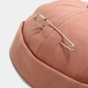 Pink cotton docker hat with silver metal pin accessory in street hip-hop style