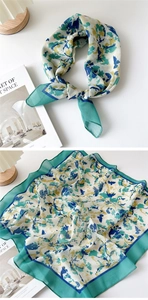 Detailed macro view showing emerald floral print and fine edge stitching on cotton linen scarf