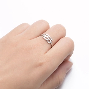 Detail of silver stainless steel ring with 555 angel number cutout design on finger