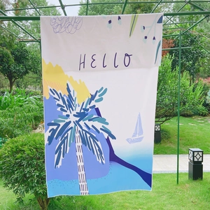 Detail of double-sided fleece beach towel featuring palm trees and artistic HELLO print