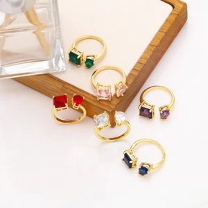 Detail of gold open rings featuring square and heart-shaped colorful zircons in a set