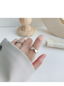On-hand display of S925 silver Mobius twisted and geometric rings on wooden base
