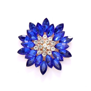 Golden sunflower brooch with marquise blue rhinestones and white crystal center