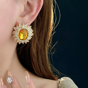 Detail of vintage sunflower earring featuring a yellow gemstone and sparkling crystals