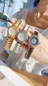 Detailed view of three fashion watches with rhinestone bezels and ceramic metal bands