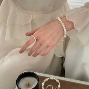 Detailed set of natural freshwater pearl bracelet and ring on a soft background